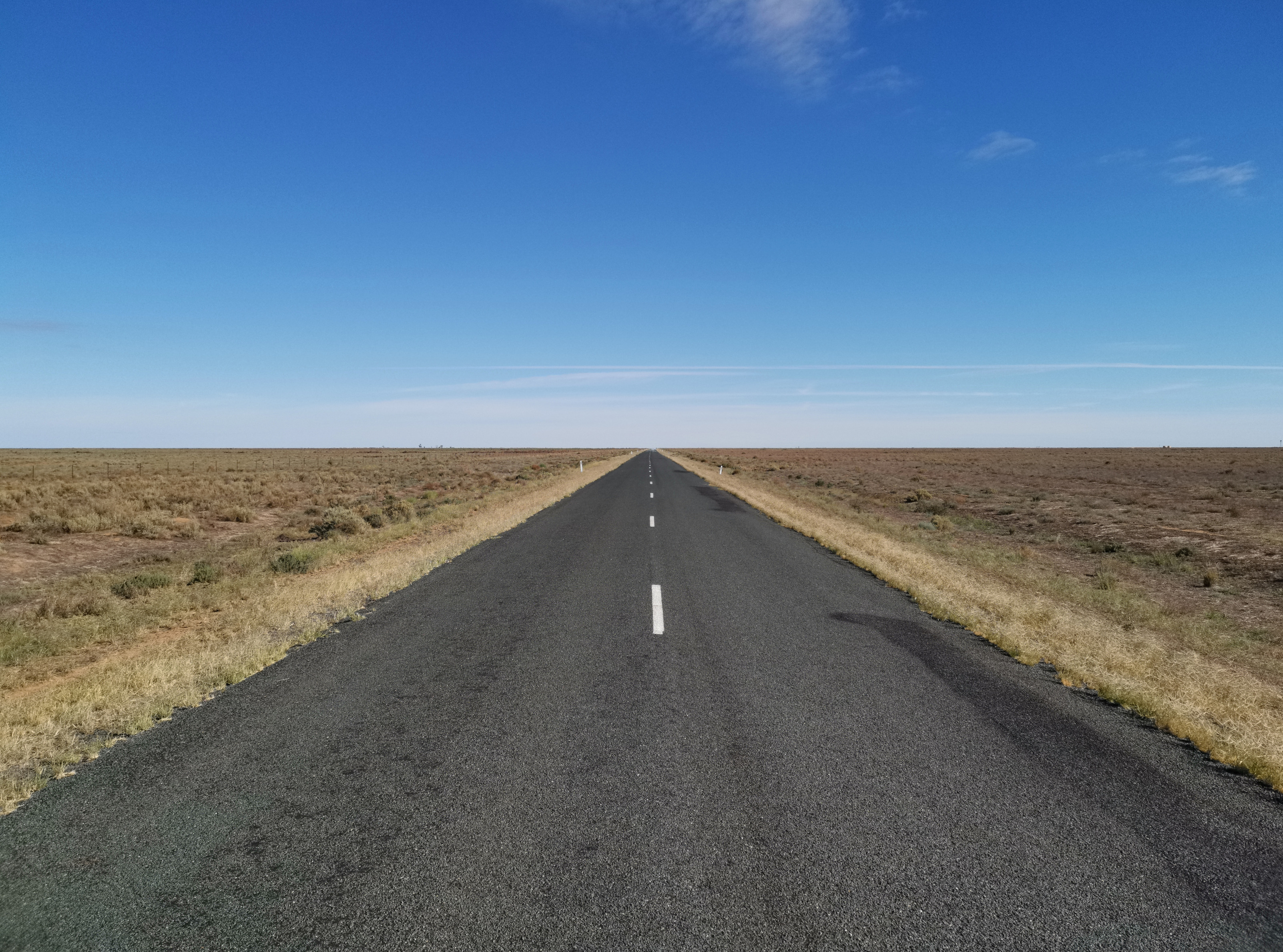 image of straight road over flat plains north of Hay, New South Wales